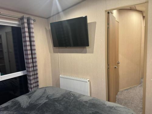 a bedroom with a flat screen tv on the wall at Nick's Retreat in Clitheroe
