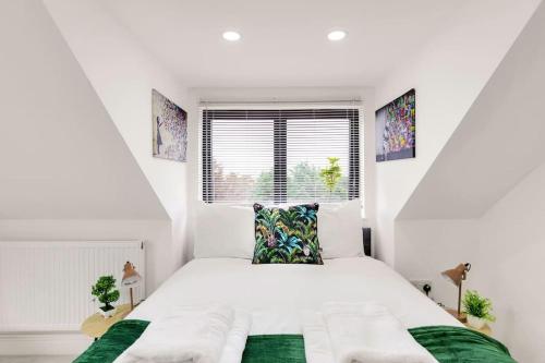 a white bedroom with a bed and a window at Chic 4 person penthouse & views West London W7 Modern free parking (4 occupancy) in London