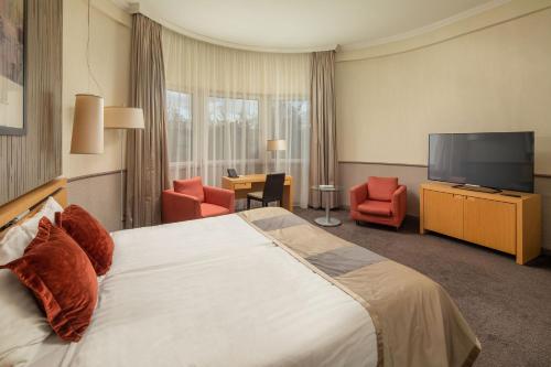 a hotel room with a bed and a flat screen tv at Mamaison Hotel Andrassy Budapest in Budapest