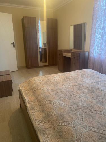 a bedroom with a large bed and a bathroom at Happy home Narimanov in Baku