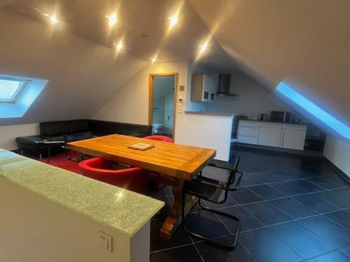 Il comprend un salon avec une table en bois et une cuisine. dans l'établissement VILLAGE, à Galfingue