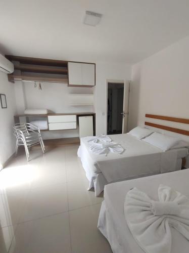 a hotel room with two beds and a kitchen at HOTEL ENSEADA BEIRA MAR in Guarujá