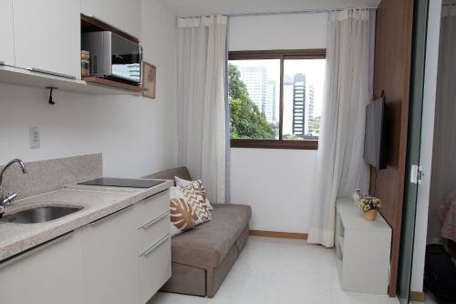 ein kleines Apartment mit einem Sofa und einem Fenster in der Unterkunft Salvador / Perto do Shopping Salvador e Shopping da Bahia / Caminho das Árvores in Salvador