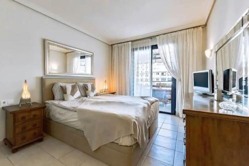 a bedroom with a large bed and a television at Balcón De Los Gigantes, Puerto de Santiago in Puerto de Santiago
