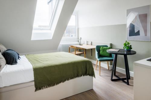 a bedroom with a bed and a table and a chair at POHA House Büchel in Aachen