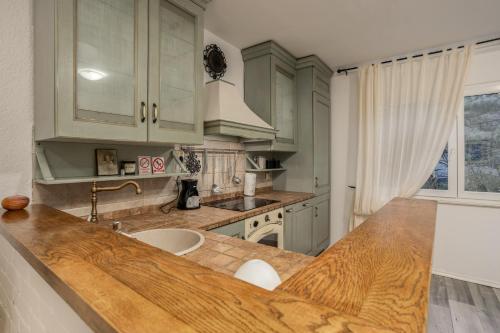 uma cozinha com armários verdes e um balcão de madeira em Apartman “Destiny” em Rijeka