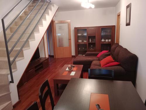 a living room with a couch and a staircase at La casita de Miguel, con garaje y piscina in Zamora