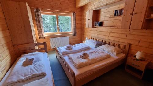 a bedroom with two beds in a log cabin at Pension Bischof Lachtal in Lachtal