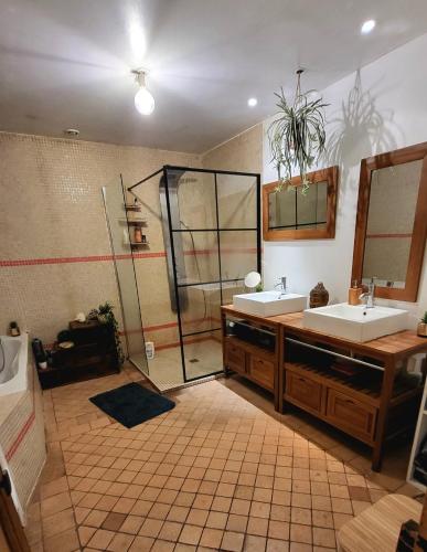 une salle de bain avec deux lavabos et une douche dans l'établissement Nid Charentais Angouleme pool jacuzzi, à La Poterie