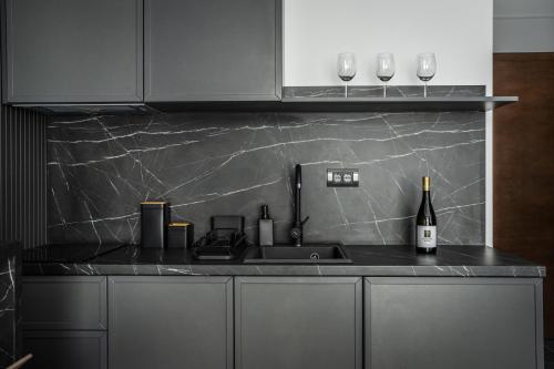 a kitchen counter with a sink and a bottle of wine at Marrilux apartments Residence Hill in Kopaonik