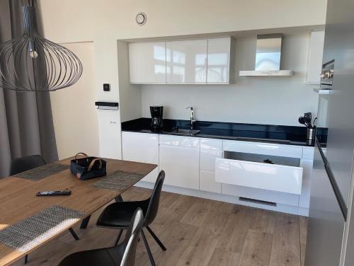 una cucina con tavolo in legno, sedie e bancone di Chalet Meeresblick Zweite Reihe Haus Nr 250 a Enkhuizen