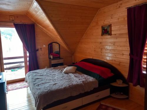 a bedroom with a bed in a log cabin at Cabana Dani in Vatra Dornei