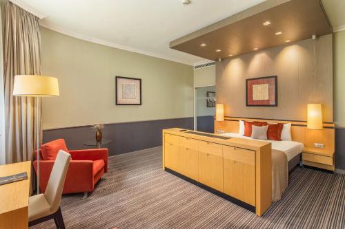 a hotel room with a bed and a chair at Mamaison Hotel Andrassy Budapest in Budapest