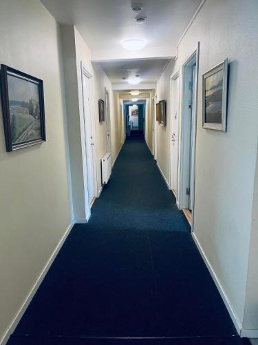 un largo pasillo con una alfombra azul en un edificio en Cilla och Smillas AB, en Malmö