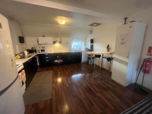uma cozinha com pisos em madeira e um frigorífico branco em Cilla och Smillas AB em Malmo