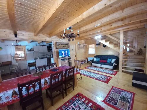 a dining room and living room with a table and chairs at Cabana Dani in Vatra Dornei