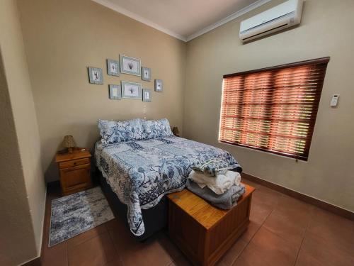 Schlafzimmer mit einem Bett und einem Fenster in der Unterkunft Home on a Hill Accommodation in Tzaneen