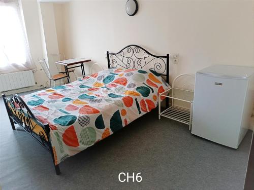 - un lit avec une couette colorée dans une chambre dans l'établissement HOTEL LE FONTENOY, à Provins