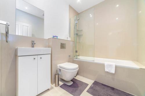 a bathroom with a toilet and a shower and a sink at Brand New Self-Contained 1 BDR Apt in Paddington in London
