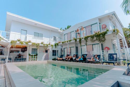 um grupo de pessoas sentadas em cadeiras ao lado de um edifício em Surf Inn Boutique Backpackers - FREE BREAKFAST em Gold Coast