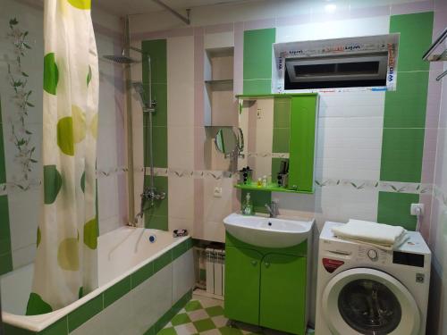een groene badkamer met een wasmachine en een wastafel bij Dushanbe intourist apartment in Dushanbe