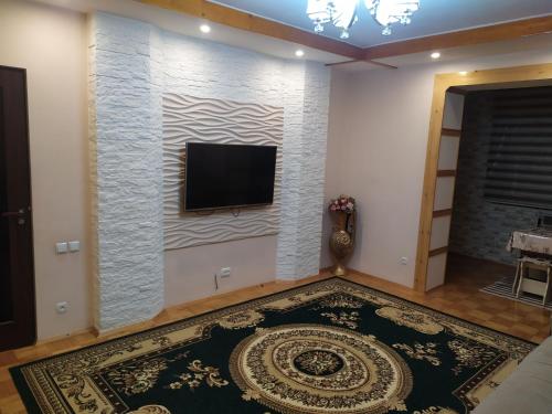 een woonkamer met een flatscreen-tv aan de muur bij Dushanbe intourist apartment in Dushanbe