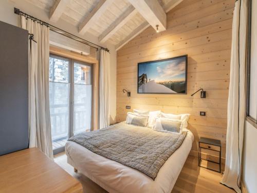 ein Schlafzimmer mit einem Bett und einem großen Fenster in der Unterkunft Appartement La Tania, 3 pièces, 4 personnes - FR-1-568-23 in Courchevel