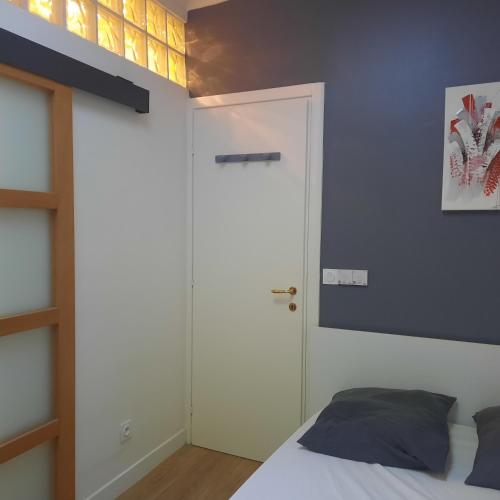 - une chambre avec un lit blanc et un mur bleu dans l'établissement Logis Capodanna, à Menton