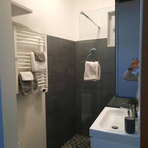 une personne prenant une photo d'une salle de bains avec lavabo dans l'établissement Logis Capodanna, à Menton