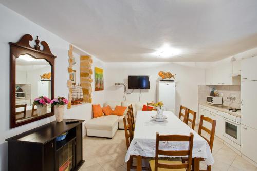 a kitchen and a living room with a table and chairs at Apartments Ferina in Poljana