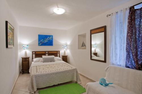 a bedroom with two beds and a couch and a mirror at Apartments Ferina in Poljana