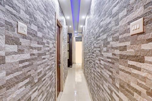 a hallway with a brick wall at Collection O Hotel Shree Narayan Regency in Kānpur