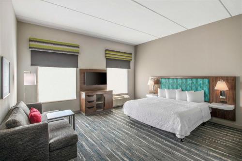 a hotel room with a bed and a couch at Hampton Inn & Suites Dallas-Allen in Allen