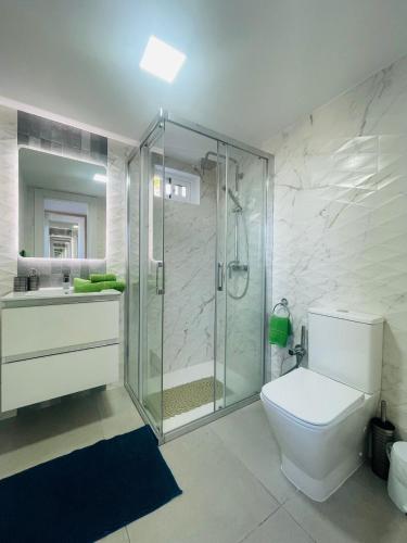 a bathroom with a shower and a toilet and a sink at La Dolce Vita Penthouse 2 Bedroom Apartment in Arona