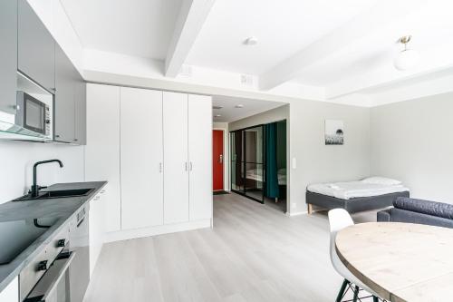 a kitchen and dining room with white cabinets and a table at Spot Apartments Hyrylä in Hyrylä