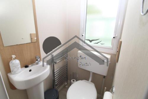a small bathroom with a toilet and a sink at Serenity - 8 Berth 3 Bedroom Static Caravan in Heysham