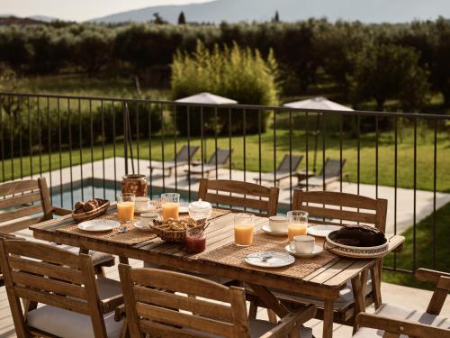 a wooden table with food and drinks on a patio at PHI Simple Living Quarters in Akrotiri