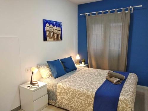 a bedroom with blue walls and a bed with blue pillows at Hostal Urban Basic in Hospitalet de Llobregat