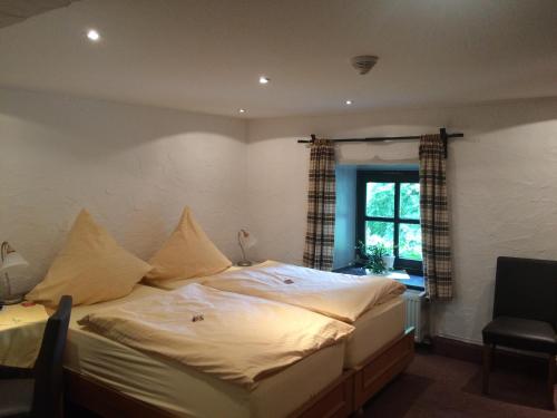 a large bed in a room with a window at Hotel-Restaurant Haus Berkenbaum in Kierspe
