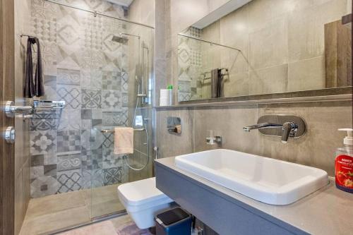 een badkamer met een wastafel, een douche en een toilet bij Homely & Spacious 2 bd Apt at Skynest (902) in Nairobi