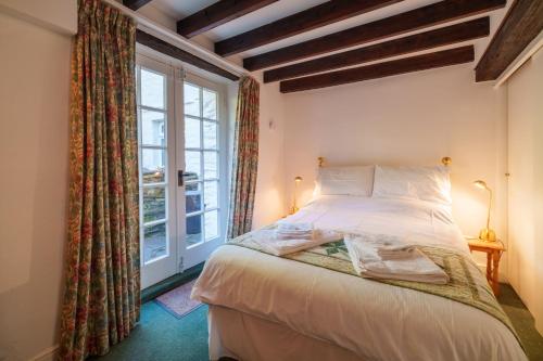 a bedroom with a bed and a window at Damson Cottage - Chocolate Box Cottage in Crook, near Bowness in Crook