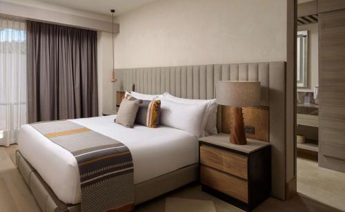 a hotel room with a large bed and a lamp at NUMU Boutique Hotel, The Unbound Collection by Hyatt in San Miguel de Allende