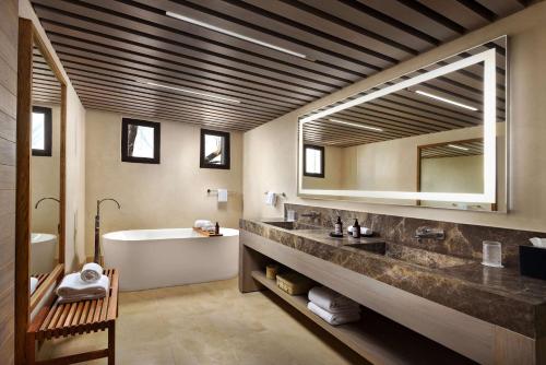 a bathroom with a tub and a sink and a mirror at NUMU Boutique Hotel, The Unbound Collection by Hyatt in San Miguel de Allende