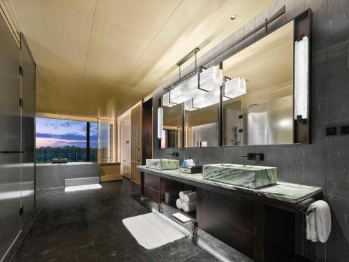a bathroom with a large sink and a large mirror at Hilton Nanjing Niushoushan in Nanjing