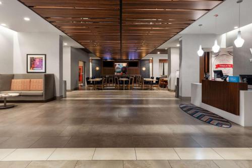 Hampton Inn by Hilton Nashville Airport Century Place في ناشفيل: لوبي فيه طاولات وكراسي في مبنى