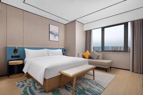 a hotel room with a large bed and a couch at Hilton Garden Inn Zigong High-Tech Zone in Zigong