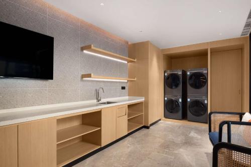 a laundry room with a sink and two washer and dryers at Hilton Garden Inn Zigong High-Tech Zone in Zigong