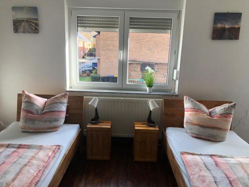 two beds in a room with a window at Haus Bergglück in Hückelhoven