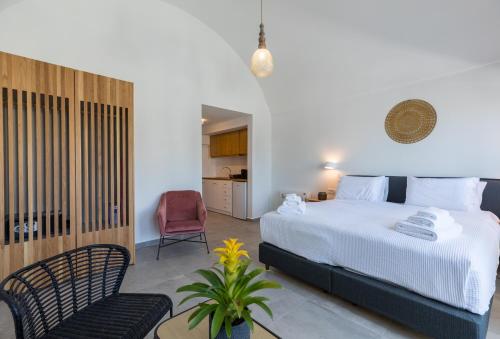 ein Schlafzimmer mit einem Bett und einem Stuhl in einem Zimmer in der Unterkunft Nostos Apartments Kamari in Kamari