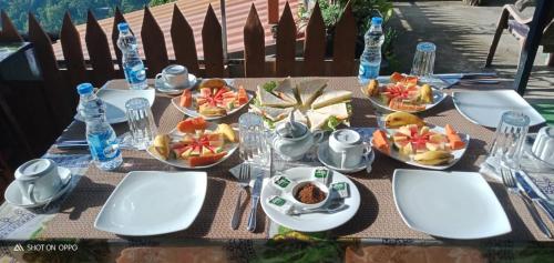 uma mesa com pratos de alimentos e garrafas de água em Mars Wonderland View em Ella
